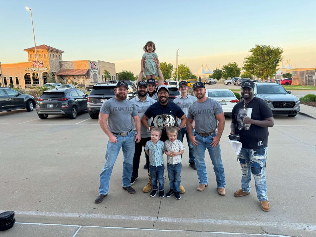 Team flex standing in parking lot.