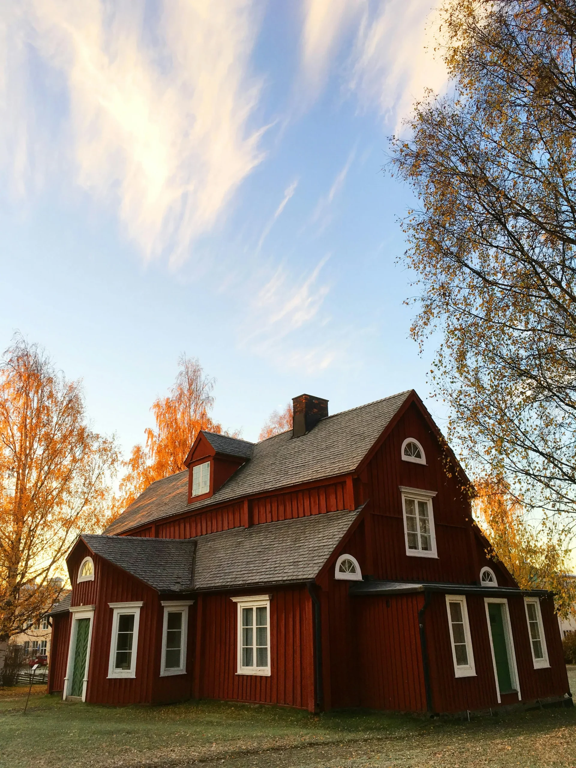 Red house in the country with a new roof.